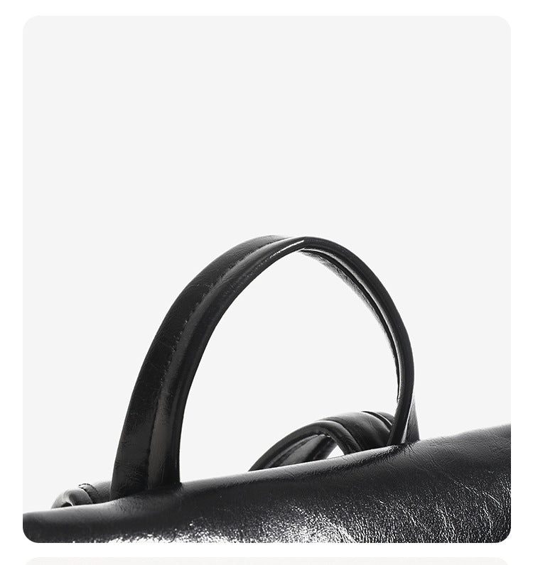 Structured glossy leather-look flap backpack handbag with dual buckle closures, top handle, and silver-tone hardware, detail