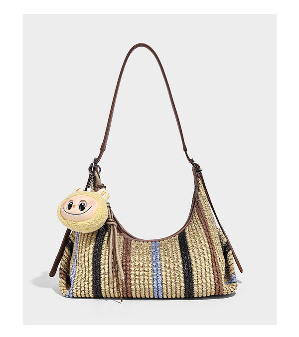 Slouchy woven straw hobo shoulder bag with beige, black, brown, and blue vertical stripes and brown leather-look trim, detail