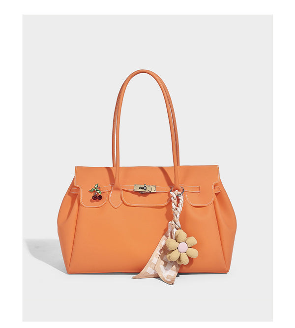 Strukturierte matte Jelly-Tote-Bag mit goldfarbenem Drehverschluss an der Klappe, zwei Schulterriemen, seitlichen Einsätzen und dekorativen
