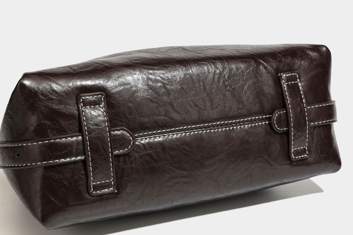 Slouchy hobo shoulder bag in glossy crinkled leather-look finish with zip-top closure and silver-tone ring hardware, detail