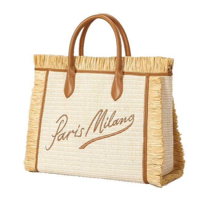 Naturfarbene, elfenbeinfarbene Strohtasche mit gewebter Optik, Bastfransenbesatz, cognacfarbenen Henkeln in Lederoptik und aufgesticktem Schriftzug „Paris Milano“