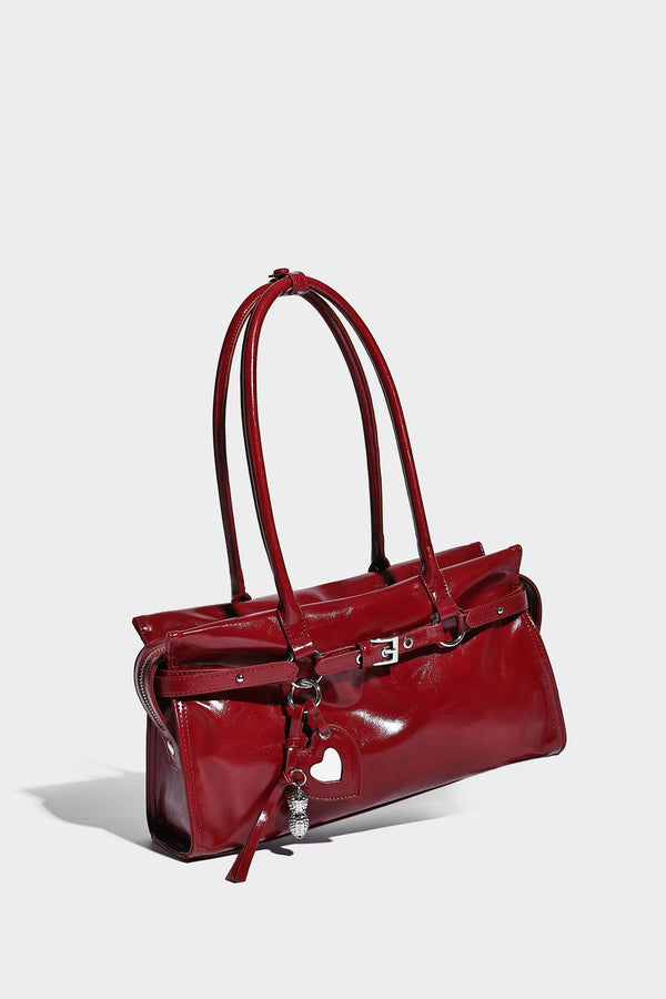 Structured rectangular glossy tote shoulder bag with belt buckle front strap and dangling charm hardware, detail view 18