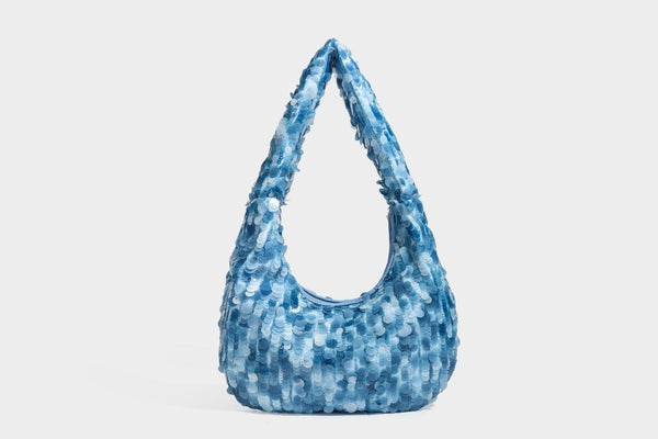 Slouchy crescent hobo shoulder bag covered in overlapping reflective sequin discs with a single integrated strap and top-zip