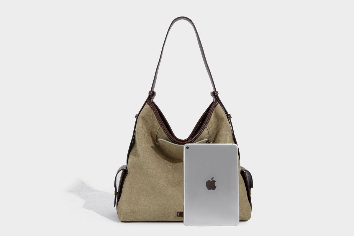 Lässig fallende Hobo-Schultertasche in Khaki aus mattem Material in Wildlederoptik mit dunkelbraunem Besatz in Lederoptik, Quastenanhänger mit Perlen und seitlicher Klappe, Detailansicht