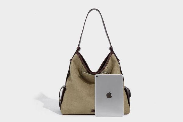 Lässig fallende Hobo-Schultertasche in Khaki aus mattem Material in Wildlederoptik mit dunkelbraunem Besatz in Lederoptik, Quastenanhänger mit Perlen und seitlicher Klappe, Detailansicht