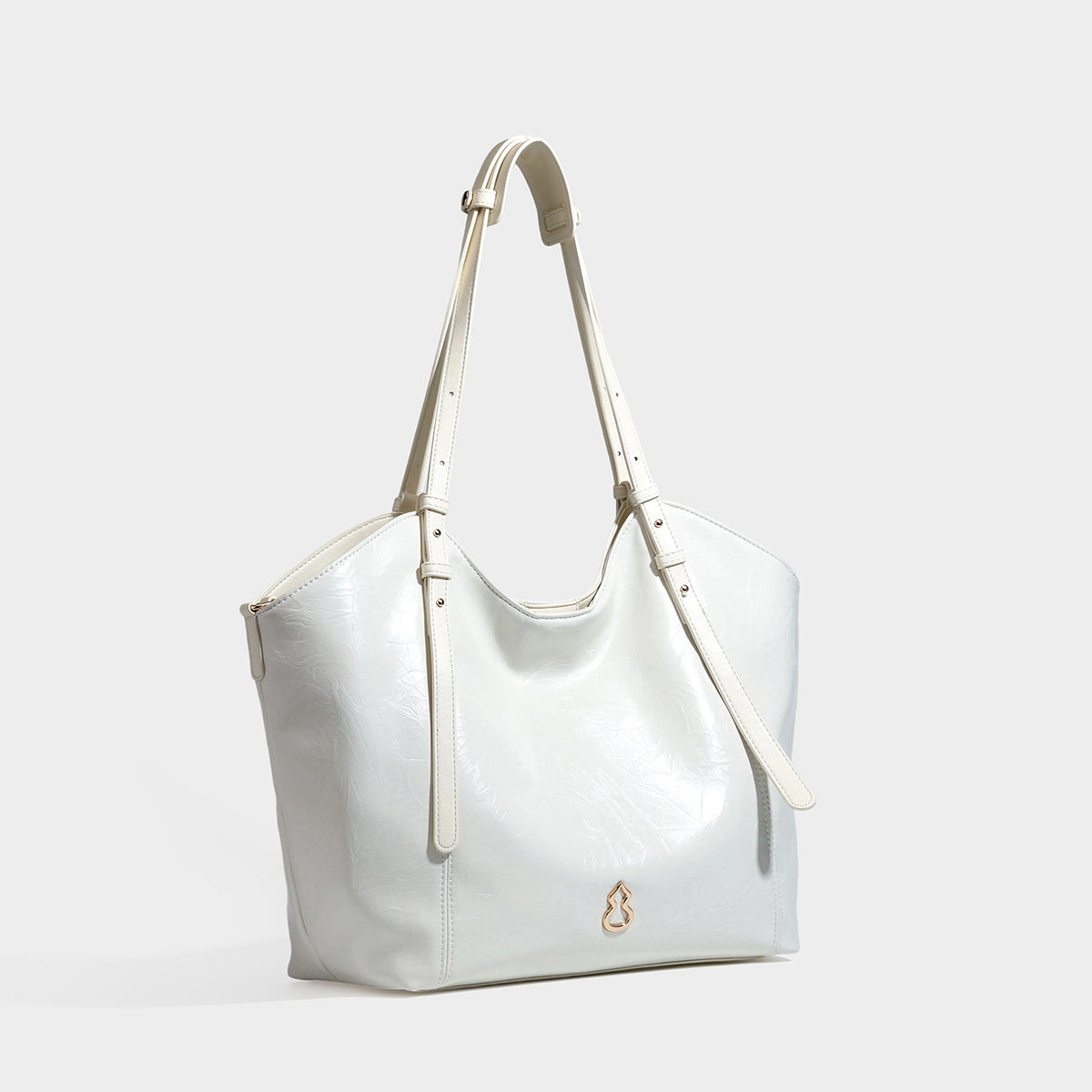 Große, glänzende Tote-Bag in geknitterter schwarzer Lederoptik mit lässiger Trapezform, zwei Schulterriemen und goldfarbenem