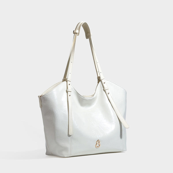 Große, glänzende Tote-Bag in geknitterter schwarzer Lederoptik mit lässiger Trapezform, zwei Schulterriemen und goldfarbenem