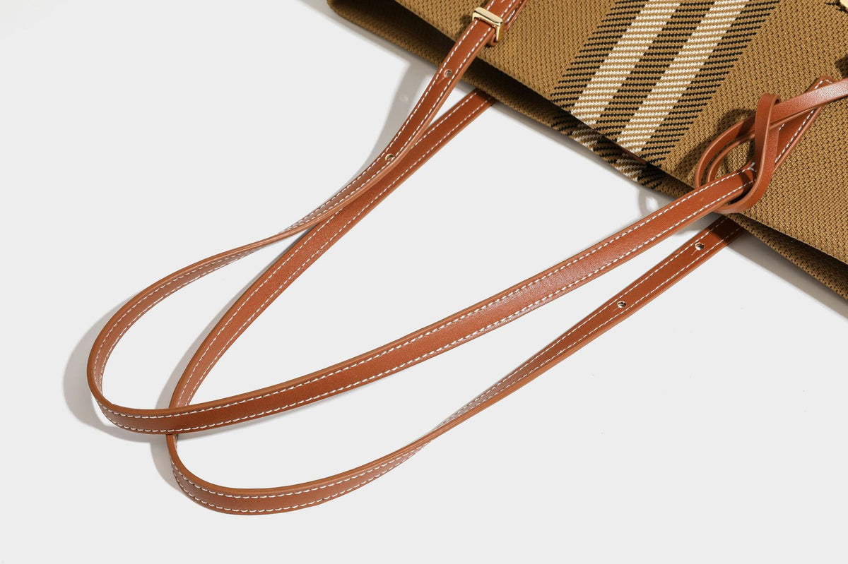 Large structured plaid check tote bag with smooth tan leather-look shoulder straps, attached front zip pouch, and gold-tone