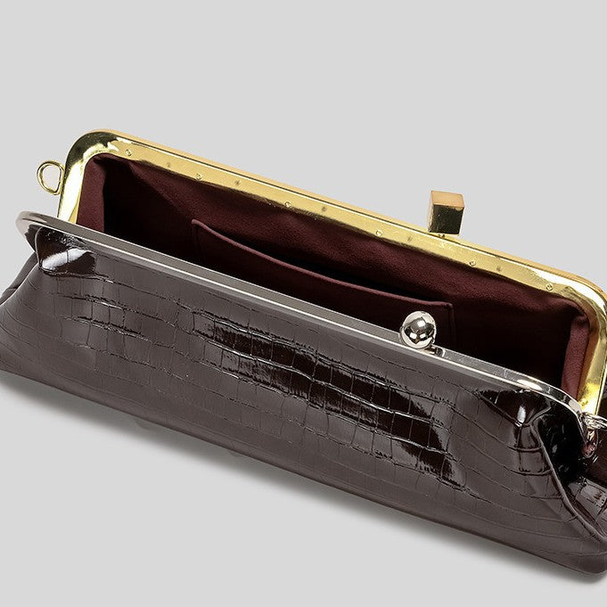 Strukturierte Clutch mit Kiss-Lock-Rahmenverschluss aus dunkelbrauner, krokodil-geprägter Lederoptik mit goldfarbenen Details und schmalem