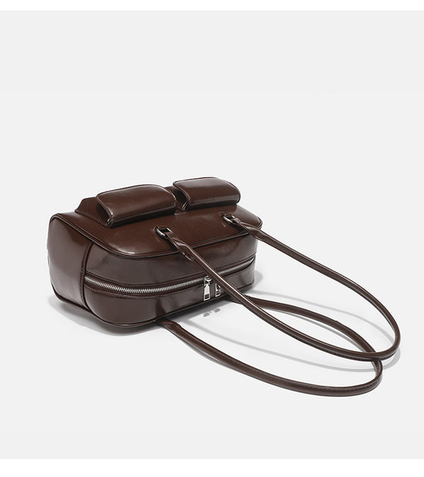 Structured glossy leather-look bowling shoulder bag with two front flap pockets, top zip closure, and long double shoulder