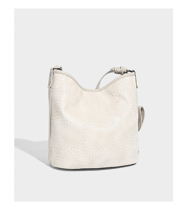 Diamond-quilted leather-look bucket shoulder bag with knotted strap accent and attached mini pouch, detail view 12