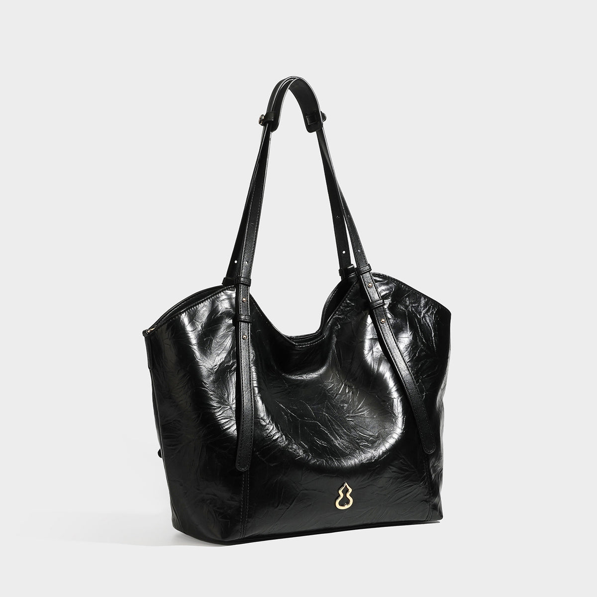 Große, glänzende Tote-Bag in geknitterter schwarzer Lederoptik mit lässiger Trapezform, zwei Schulterriemen und goldfarbenem