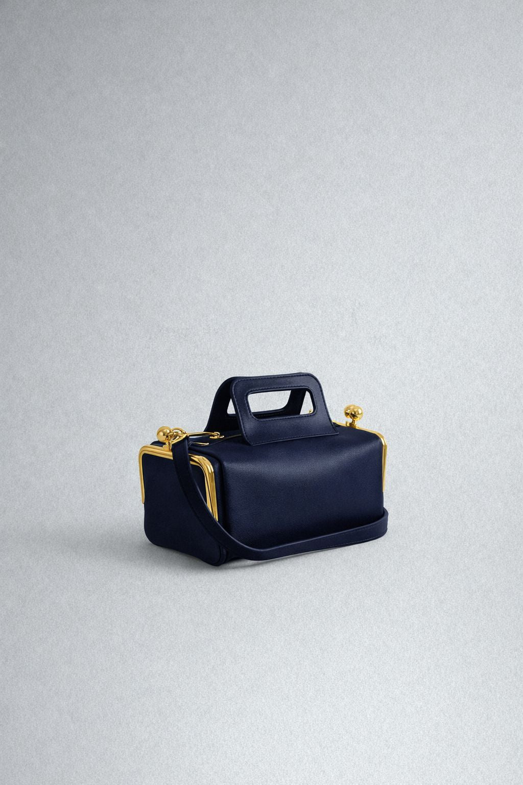 Kompakte dunkelbraune Henkeltasche in Lederoptik mit goldfarbenem Rahmenbeschlag und abnehmbarem, verstellbarem Crossbody-Riemen