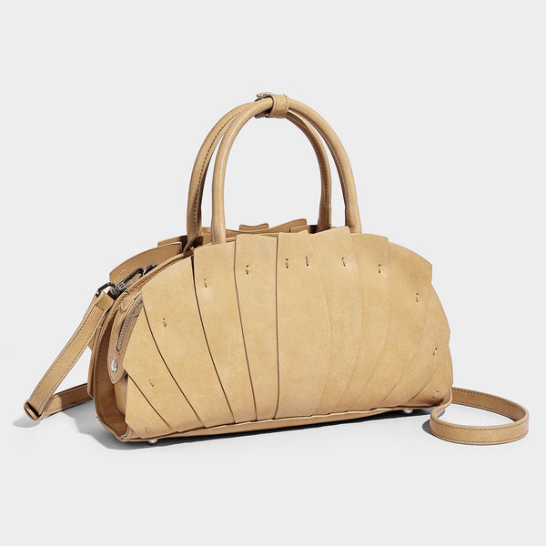 Structured dome satchel with fan-pleated leather-look exterior, dual top handles, and detachable shoulder strap, detail view