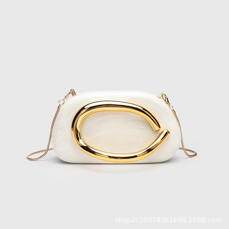Kleine rechteckige Crossbody-Clutch mit abgerundeten Ecken, oversized poliertem C-förmigem Goldgriff und schmalem Goldkettenriemen, Detailansicht
