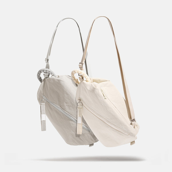 Lässige Crossbody-Bag aus weichem Stoff mit geflochtenem Kordel-Tragegriff, diagonalem Reißverschlussfach auf der Vorderseite und silberfarbenen Details, Vorderansicht