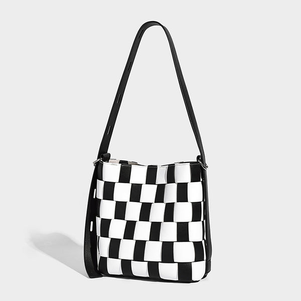 Hand-woven black-and-white checkerboard bucket bag with smooth black trim, silver-tone ring hardware, and adjustable