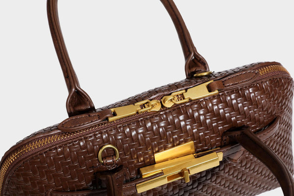 Structured woven-embossed leather-look satchel with dual rolled top handles, gold-tone turn-lock closure, and detachable
