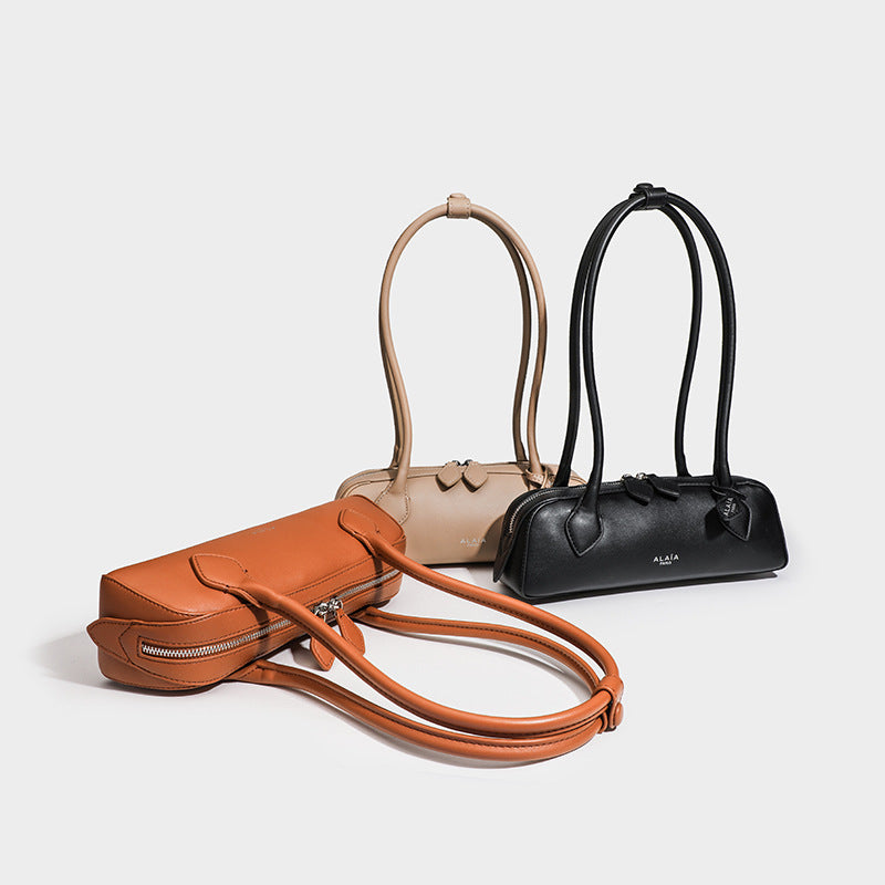 Structured baguette shoulder bag with smooth matte leather-look finish, long double straps, and top zipper closure, front