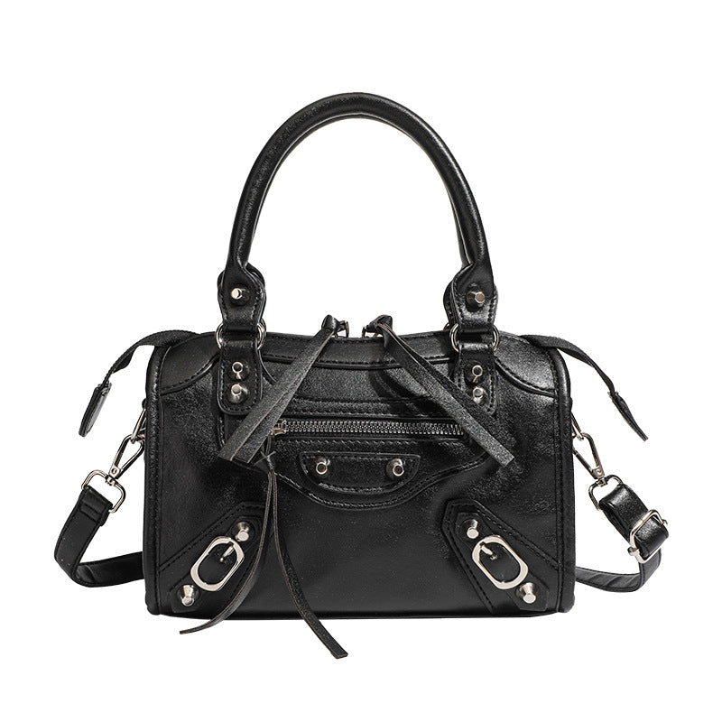 Mini-Henkeltasche mit formstabiler Silhouette, silberfarbenen Nietenbeschlägen, Reißverschlussfach vorne, zwei Tragegriffen und abnehmbarem Schulterriemen