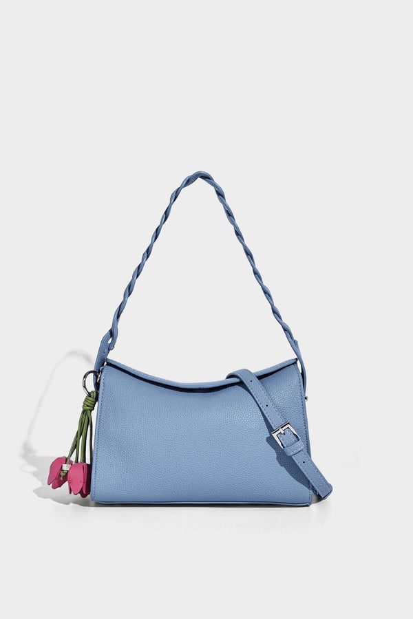 Small structured pebbled-finish shoulder bag with braided top handle, detachable crossbody strap, floral tassel charm, and