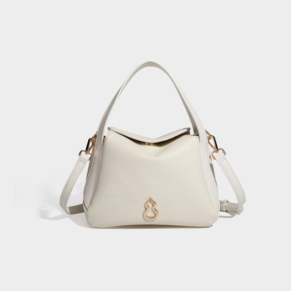 Structured pebbled leather-look shoulder bag with flap top, gold-tone emblem hardware, dual top handles, and detachable