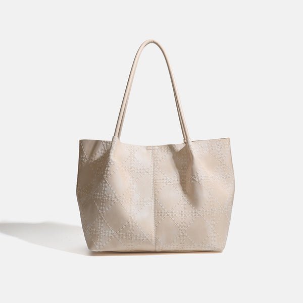 Large open-top tote bag with raised diamond-lattice stitching, long double shoulder handles, and gold-tone magnetic snap