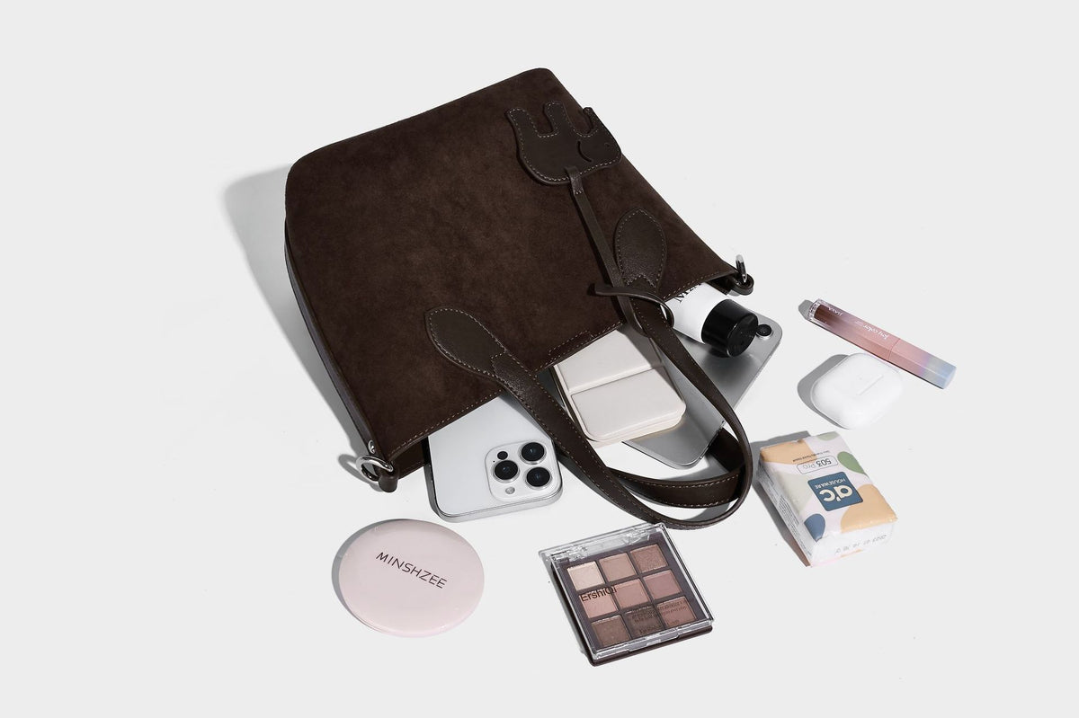 Kleine, strukturierte Tote-Handtasche in Wildlederoptik mit Elefantenanhänger, zwei oberen Tragegriffen und abnehmbarem Crossbody-Riemen, Detailansicht