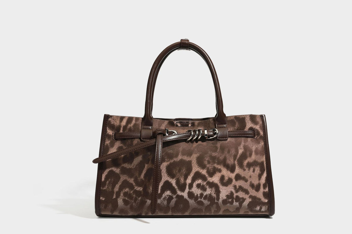 Structured leopard-print tote bag with glossy satin-like finish, dual rounded top handles, silver buckle-and-ring front