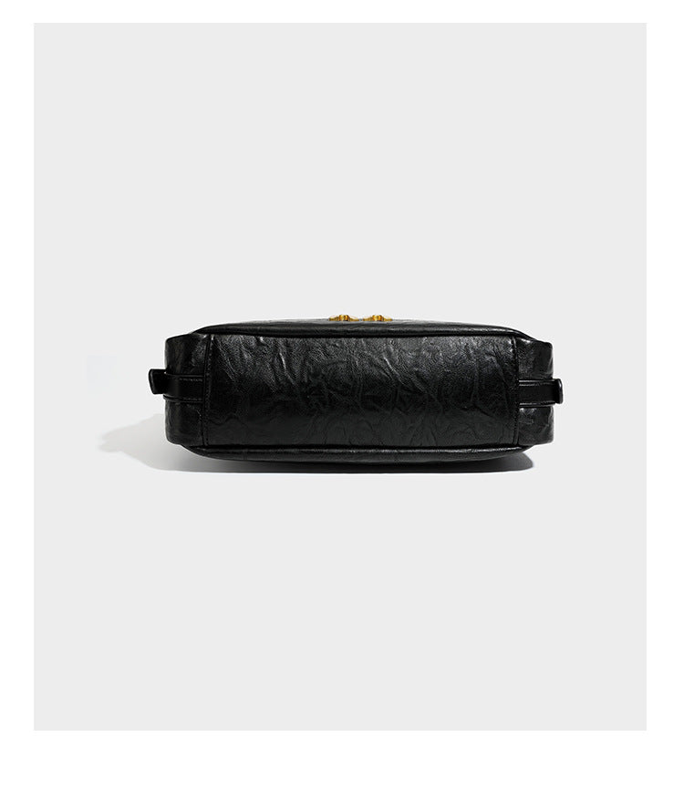 Compact black crinkled leather-look baguette shoulder bag with gold-tone arch hardware and adjustable strap, detail view 14