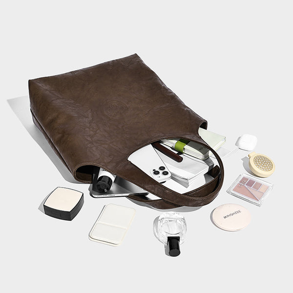 Large open-top tote bag with crinkled leather-look finish, long double shoulder straps, and embossed circular detail on