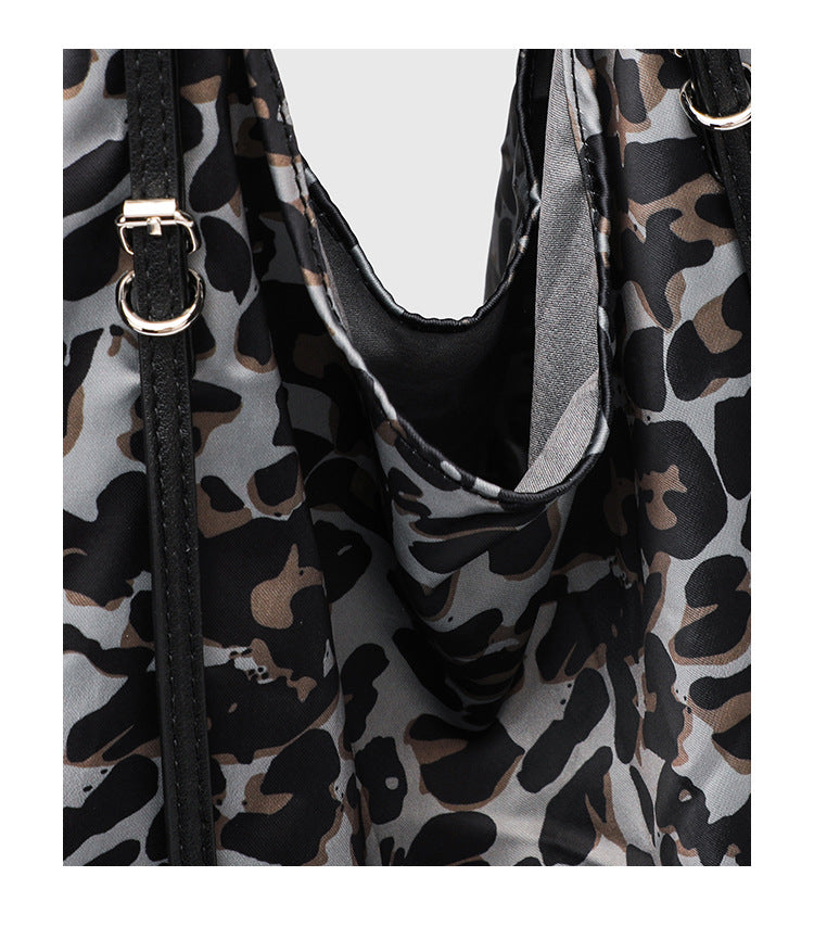 Large leopard-print slouchy tote shoulder bag in grey, black, and tan with gold-tone hardware and adjustable leather-look