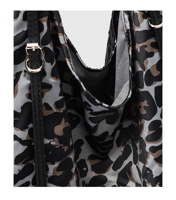 Large leopard-print slouchy tote shoulder bag in grey, black, and tan with gold-tone hardware and adjustable leather-look