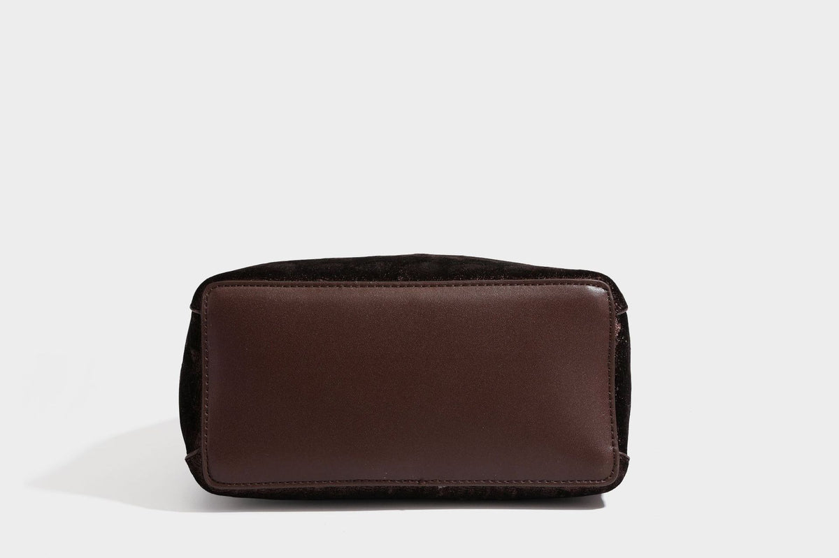 Small structured bucket satchel in embossed velvet-texture fabric with silver turn-lock hardware, rounded top handle, and