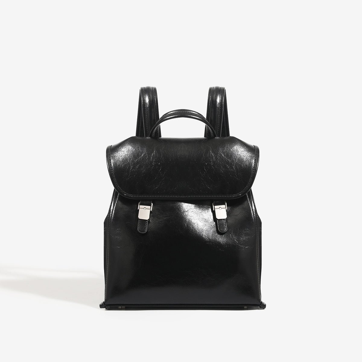 Structured glossy leather-look flap backpack handbag with dual buckle closures, top handle, and silver-tone hardware, detail