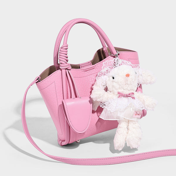 Structured mini tote bag in pebbled leather-look finish with knotted top handles, front flap pocket, and detachable shoulder
