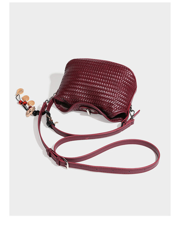Small woven-look leather-look flap shoulder hobo bag in burgundy with silver-tone hardware and decorative tassel charm