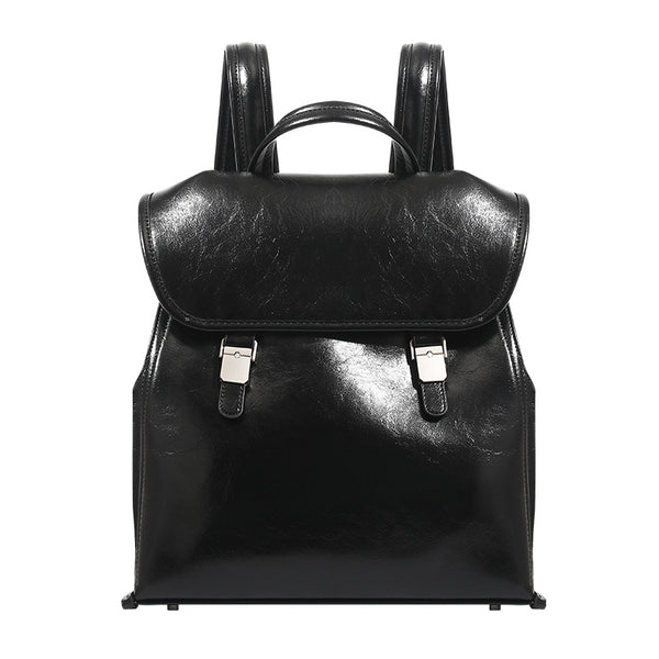Structured glossy leather-look flap backpack handbag with dual buckle closures, top handle, and silver-tone hardware, detail