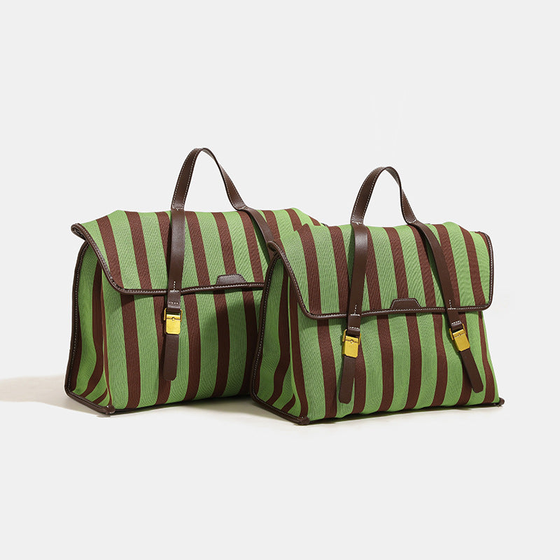 Structured striped canvas convertible satchel bag with leather-look trim, gold-tone buckle hardware, and backpack straps