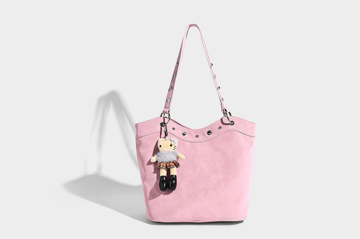 Große Tote-Bag in matter Lederoptik mit silbernen Ösen, zwei Schulterriemen und abnehmbarem Plüschpuppen-Anhänger, Detailansicht