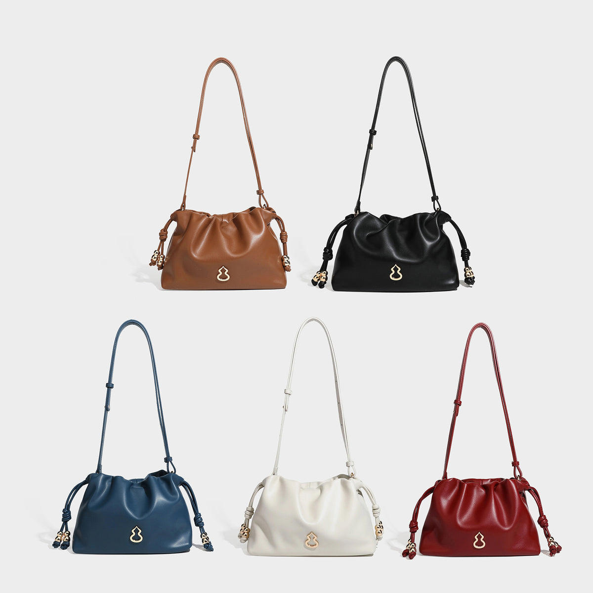 Slouchy ruched drawstring shoulder bag in smooth leather-look finish with gold-tone emblem and slim adjustable strap, detail