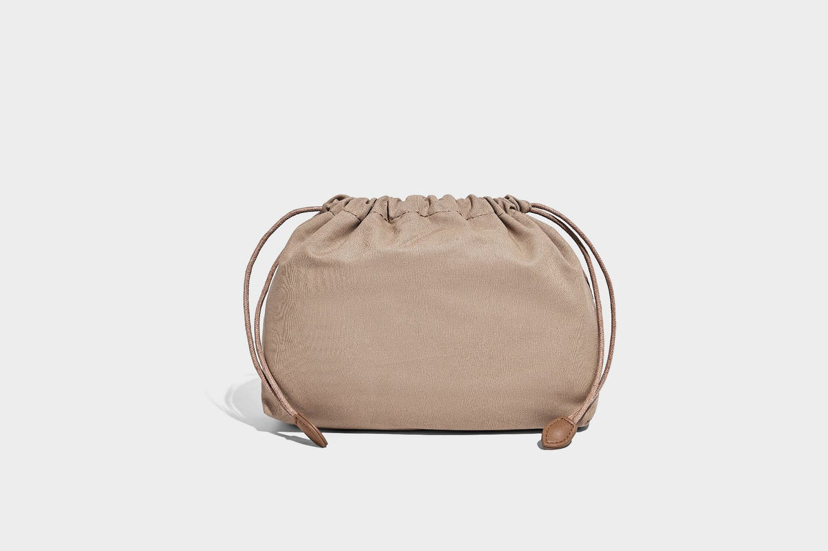 Small structured woven lattice tote bag with dual top handles and detachable shoulder strap in brown and cream leather-look