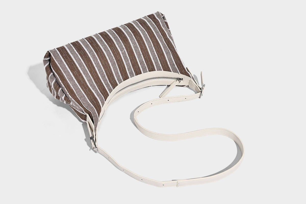 Lässig fallende, gestreifte gewebte Hobo-Bag mit kontrastierendem cremefarbenem Besatz, Reißverschluss oben und verstellbarem Riemen mit Schnalle in Silberoptik, Detailansicht
