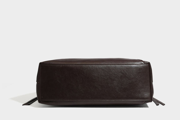 Large slouchy hobo shoulder bag with braided top handle, smooth glossy leather-look finish, and silver-tone ring hardware
