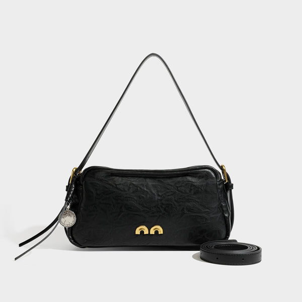 Compact black crinkled leather-look baguette shoulder bag with gold-tone arch hardware and adjustable strap, detail view 4