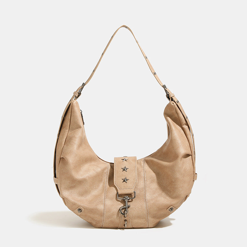 Crescent hobo shoulder bag in matte leather-look finish with star stud front panel, antique-silver hook hardware, and, detail