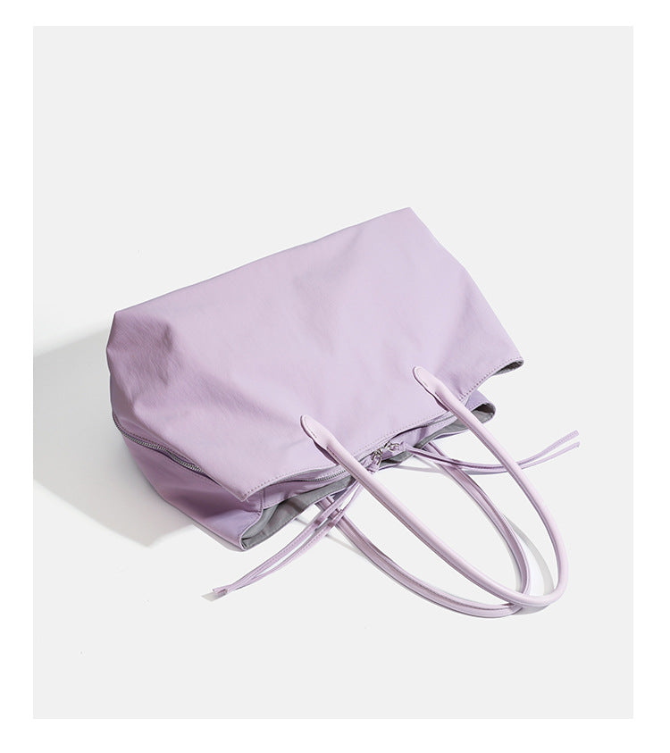 Large soft nylon tote bag with long double handles and zippered top in lavender, detail view 12