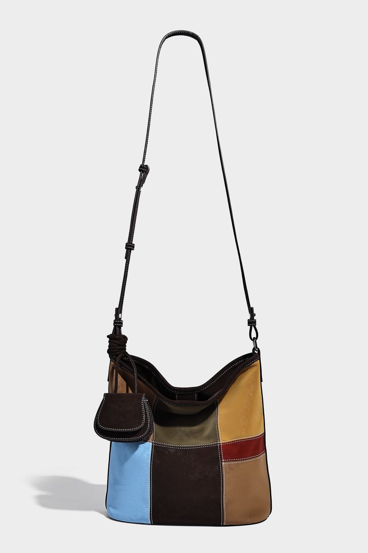 Weich fallende Patchwork-Bucket-Schultertasche mit Einsätzen in Dunkelbraun, Cognac, Senfgelb, Olivgrün, Rot und Hellblau sowie Kontrastnähten