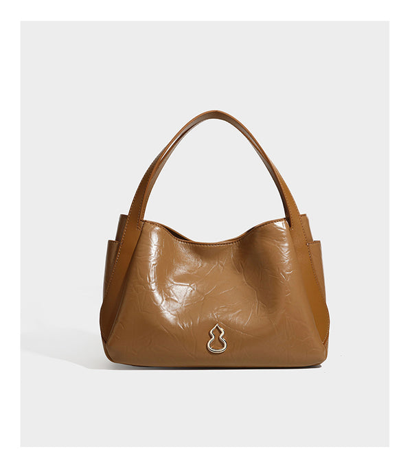 Black glossy crinkled leather-look convertible shoulder tote bag with gold gourd-shaped emblem hardware and detachable