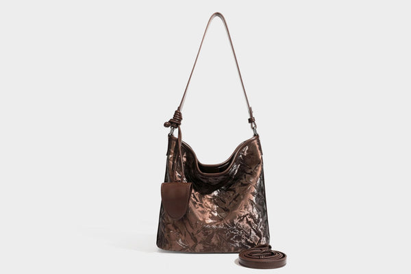 Große Hobo-Schultertasche mit Crinkle-Glanzfinish in Dunkelbraun, schmalem verstellbarem Riemen, geknoteten Beschlägen und seitlich befestigter Klappe